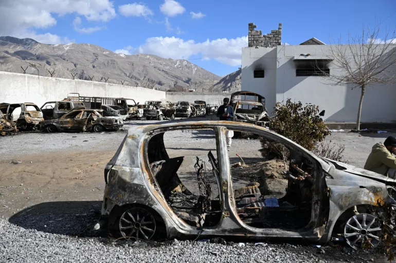 Torched vehicles sit inside a damaged police station on the outskirts of Quetta after a wave of attacks linked to Baloch separatist fighters.